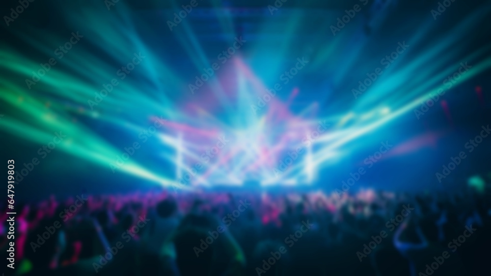 Fototapeta premium Blur crowd audience watching live show in concert hall or venue stadium with colorful lighting background