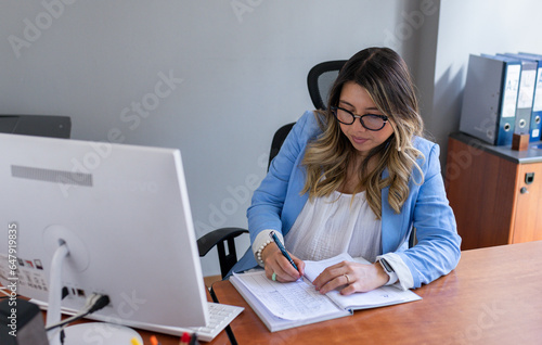 Mujer embarazada de 31 años trabajando en la oficina con su compañero hombre de 52 años. 
