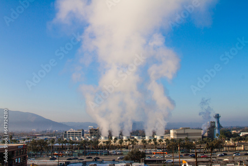 Steam power plant in the city with turbine tower with smoke