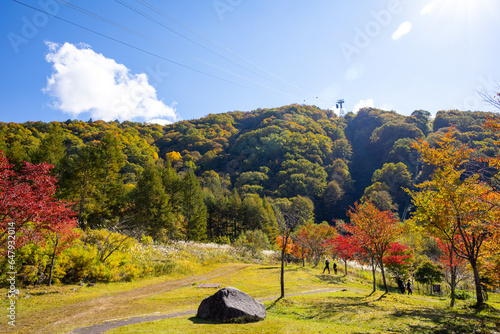 The atmosphere of the main tourist attraction Shin Hotaka in the autumn colors with a cable car and ropeway serving tourists. Japan Alps, Shinhotaka Ropeway and Fall foliage. photo
