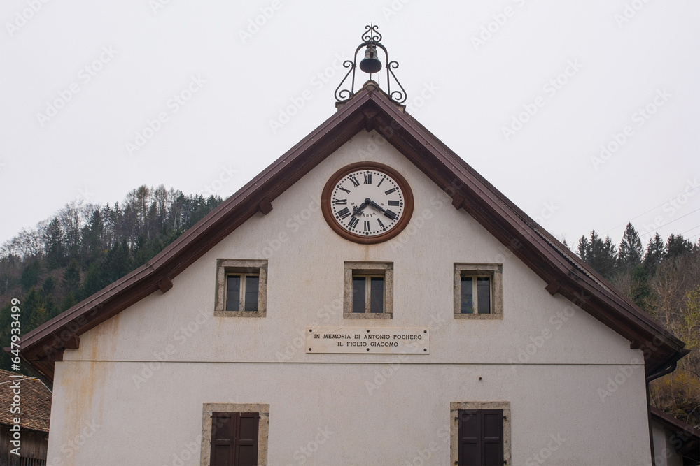 A building in the mountain village of Magnanins near Rigolato in Carnia, Friuli-Venezia Giulia, north east Italy. The plaque below the clock reads A building in the mountain village of Magnanins near Rigolato in Carnia, Friuli-Venezia Giulia, north east Italy. The plaque below the clock reads