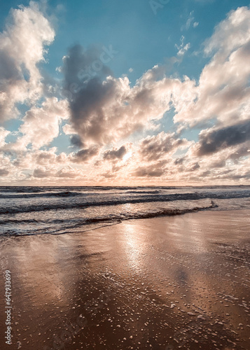 Sunset at the beach amongst dramatic clouds during golden hour