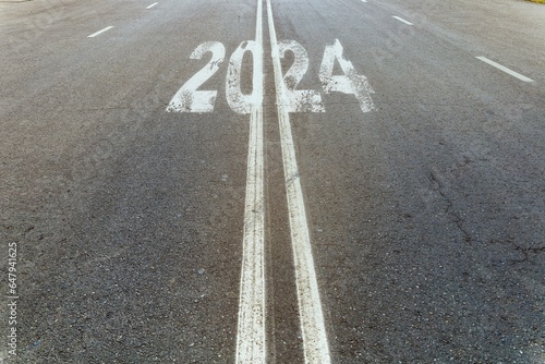 New Year 2024 or straightforward concept. The text 2024 is written on the road in the middle of the asphalt road. Concept of new life change  business strategy  opportunity  hope and motivation