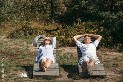 Fotografia A couple of cute elderly people are lying on sunbeds, basking in the sun