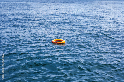 Tableau sur toile Orange life buoy floating in sea