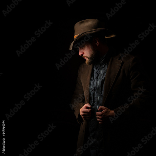 Portrait of a sad cowboy on dark background