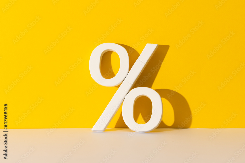White percent sign with copy space against yellow background White percent sign with copy space against yellow background