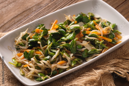 stir-fry bean sprouts, carrots, and katel (soybean shoots). Indonesian food. served in white plate. Katel is superfood from soybean typical of Majalengka regency. photo