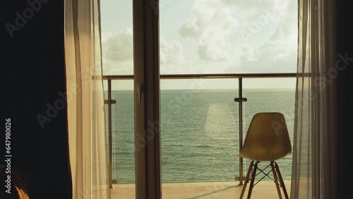 Beautiful View from the Balcony Window of a House on the Sea, Clouds at Sunset. Ocean Window View of an Apartment, Dawn Cloudy Sky. Travel, Vacation, Relaxation, Beauty.