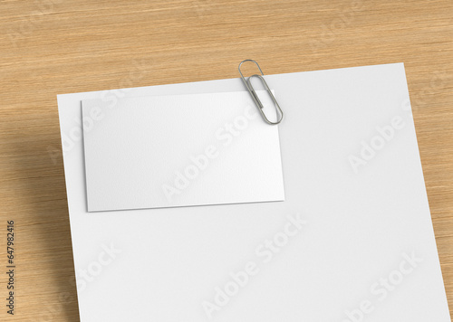 White Blank Empty Plain Business Card Clipped with Paper Clip On a Letterhead On Wooden table