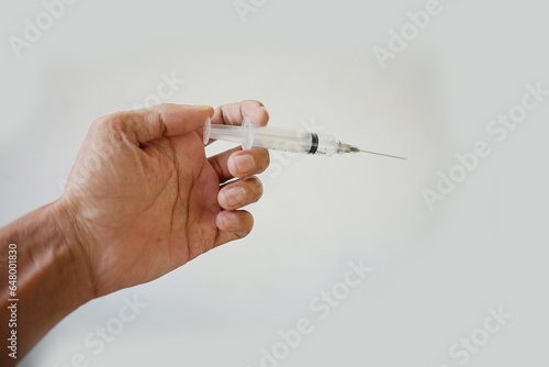 picture of Asian man's hand holding a medical injection tool isolated on white background