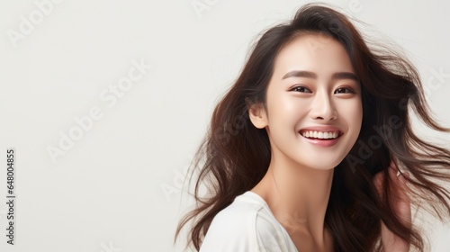 Beautiful young Asian woman smiling with clean teeth on white background.