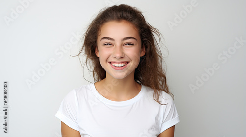 young beautiful girl with a happy expression smiling sweetly wearing a white t-shirt on a white background created with Generative AI Technology