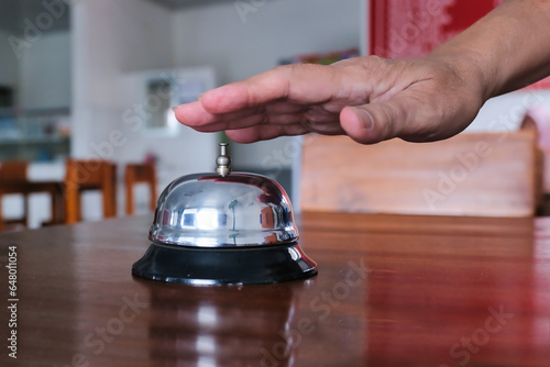 A silver service bell on a wooden desk to call for assistance photo