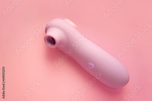 Purpe sex toy with vacuum suction on the pastel pink background