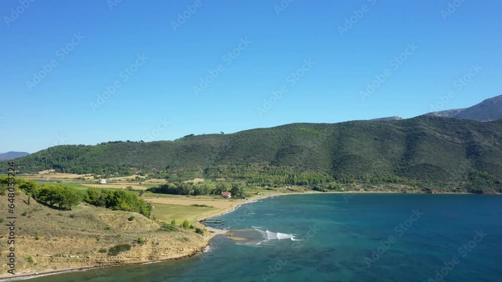 The municipality at the edge of the rocky coast among the green country landscape, Europe, Greece, Aetolia Acarnania, Kato Vasiliki towards Patras, by the Ionian Sea, in summer, on a sunny day. The municipality at the edge of the rocky coast among the green country landscape, Europe, Greece, Aetolia Acarnania, Kato Vasiliki towards Patras, by the Ionian Sea, in summer, on a sunny day.