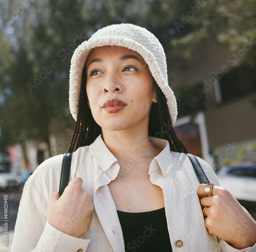 Woman, thinking closeup and gen z fashion in city with travle and freedom from urban adventure in New York. Female teenager relax, streetwear and backpack and outdoor on a journey in town on a trip photo