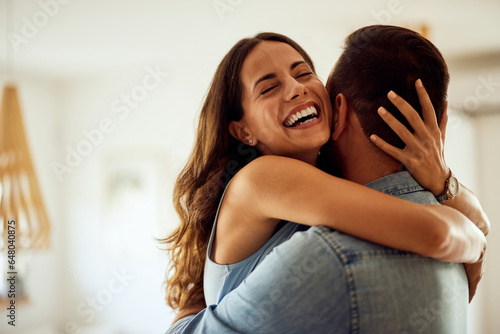 A close-up of a happy woman enjoying hugging her boyfriend at home. photo