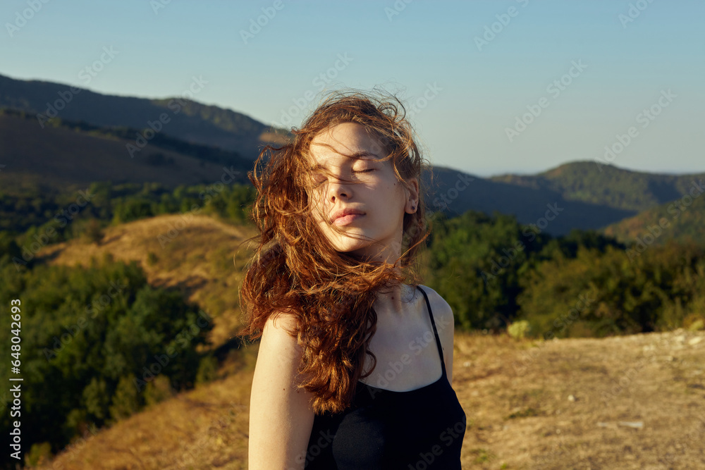 portrait of a happy woman in the mountains, with her hair blown by the wind on a sunny day portrait of a happy woman in the mountains, with her hair blown by the wind on a sunny day