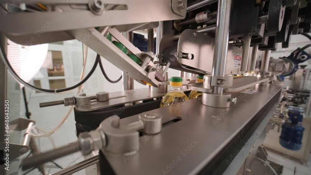Sunflower oil in the bottle moving on production line. Bottling line of sunflower oil in bottles. Vegetable oil production plant. High technology. Industrial background Sunflower oil in the bottle moving on production line. Bottling line of sunflower oil in bottles. Vegetable oil production plant. High technology. Industrial background