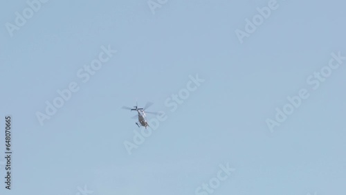 Police helicopter in flight speeding against the blue sky and flying away