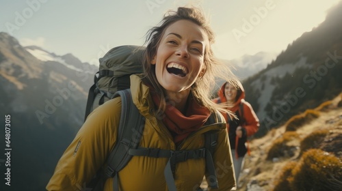 Representation of a grinning lady unwinding amid a mountain climb Female with analog camera and rucksack getting a charge out of the see whereas standing on the beat of the mountain
