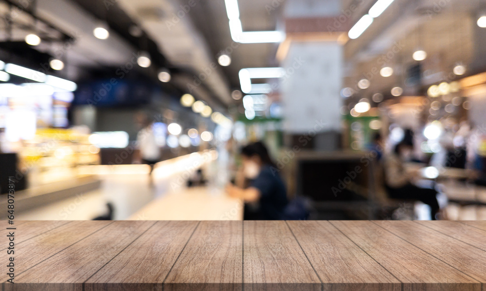 Empty wooden table top with lights bokeh on blur restaurant background.
Empty wooden table top with lights bokeh on blur restaurant background.