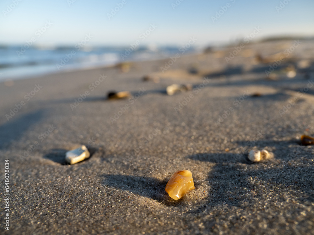 Yellow stone on a sandy beach in the evening sun Yellow stone on a sandy beach in the evening sun