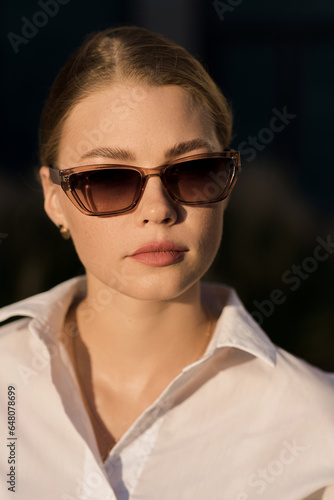 Portrait of a young and attractive Caucasian woman in casual clothes and sunglasses while walking around the city. The concept of fashion, style, youth and lifestyle © Павел Костенко
