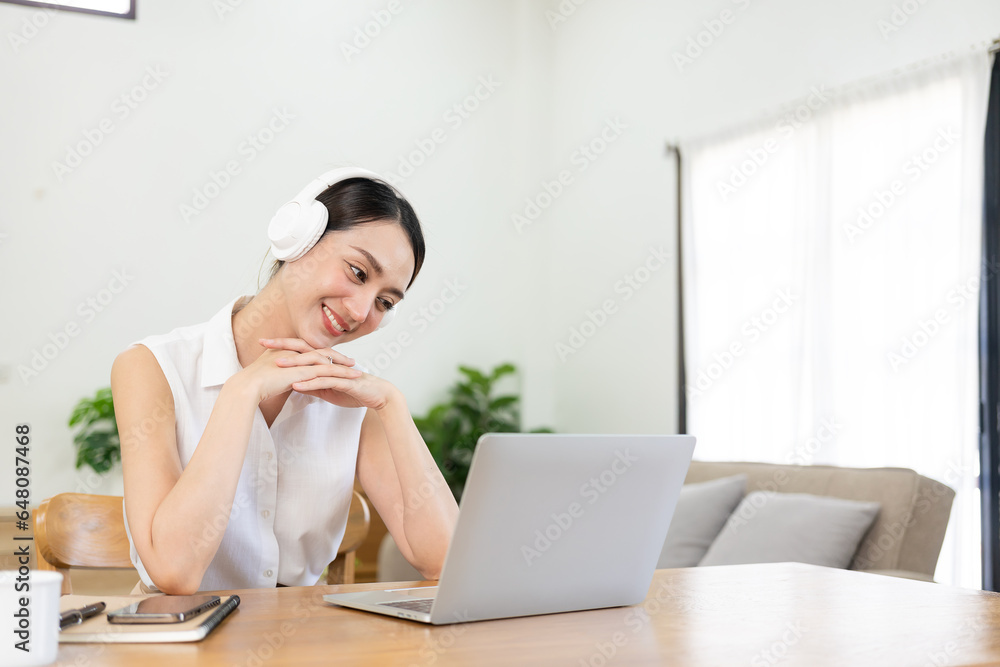 Obraz premium Beautiful Asian woman and headphones use laptop at home to write notes Attractive female student learning language Watch the webinar online online internet education