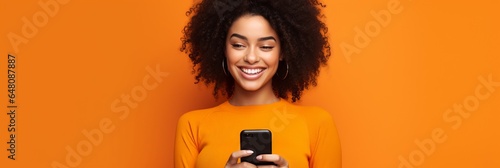 girl with phone on orange background.