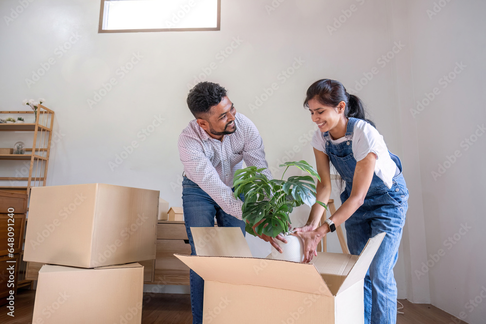 A couple moves into a new house. happily holding boxes and moving things together. A couple moves into a new house. happily holding boxes and moving things together.