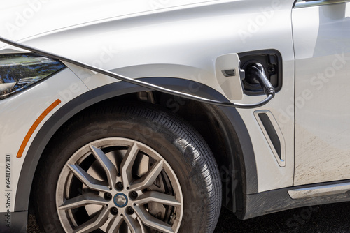 Wallpaper Mural Electric Vehicle being charged at a station in a parking lot. Torontodigital.ca