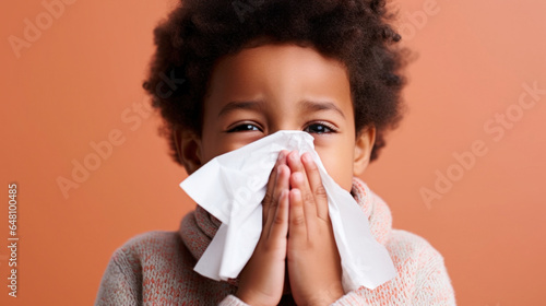 Cute kid handling a runny nose with tissue in a studio photo.