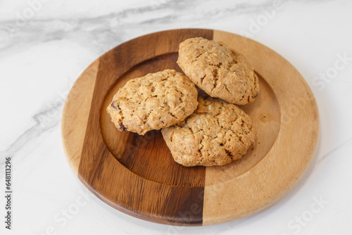 Cookies aux pépites de chocolat. Biscuit fait maison sur une assiette en bois et table en marbre. photo