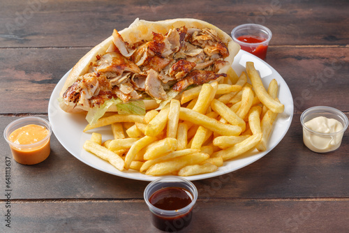 Doner kebab sandwich sur une assiette avec des frites et sauces. Spécialité culinaire turque. Restauration rapide.