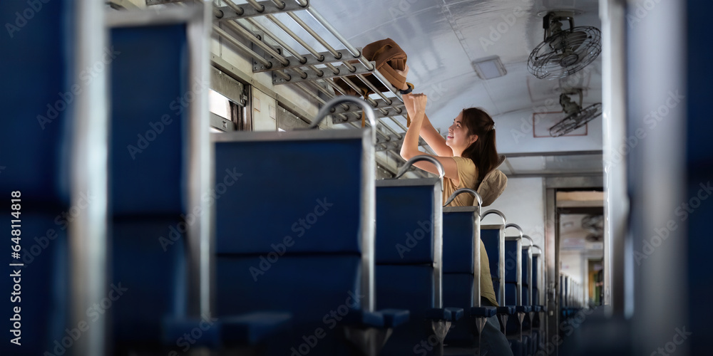 asian woman young stand interior of the train looking at Placing luggage for tourism backpacker. concept transport lifestyle active journey and travel adventure asian woman young stand interior of the train looking at Placing luggage for tourism backpacker. concept transport lifestyle active journey and travel adventure