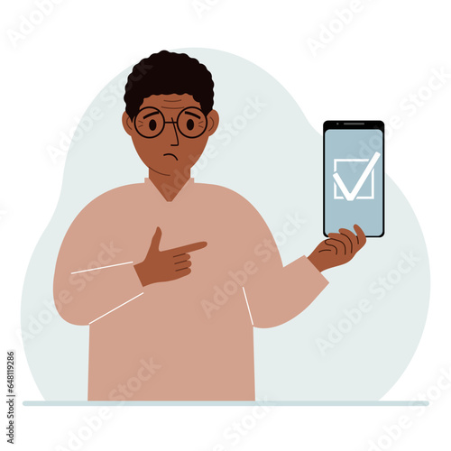 A man is holding a phone with a check mark on the screen. The concept of choice, voting or defence.