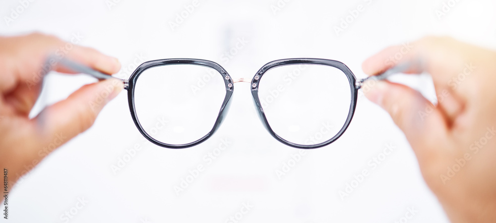 Glasses in hands, frame and vision for eye care, health and person for eyesight improvement, lens and perspective. Closeup, spectacles and optometry, designer eyewear and wellness on white background - obrazy, fototapety, plakaty 