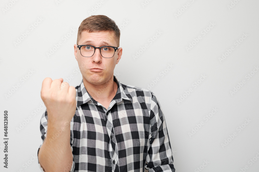 Portrait of angry young man yelling clenching fists isolated on white studio background. Devil face. Human emotions, facial expression concept Portrait of angry young man yelling clenching fists isolated on white studio background. Devil face. Human emotions, facial expression concept