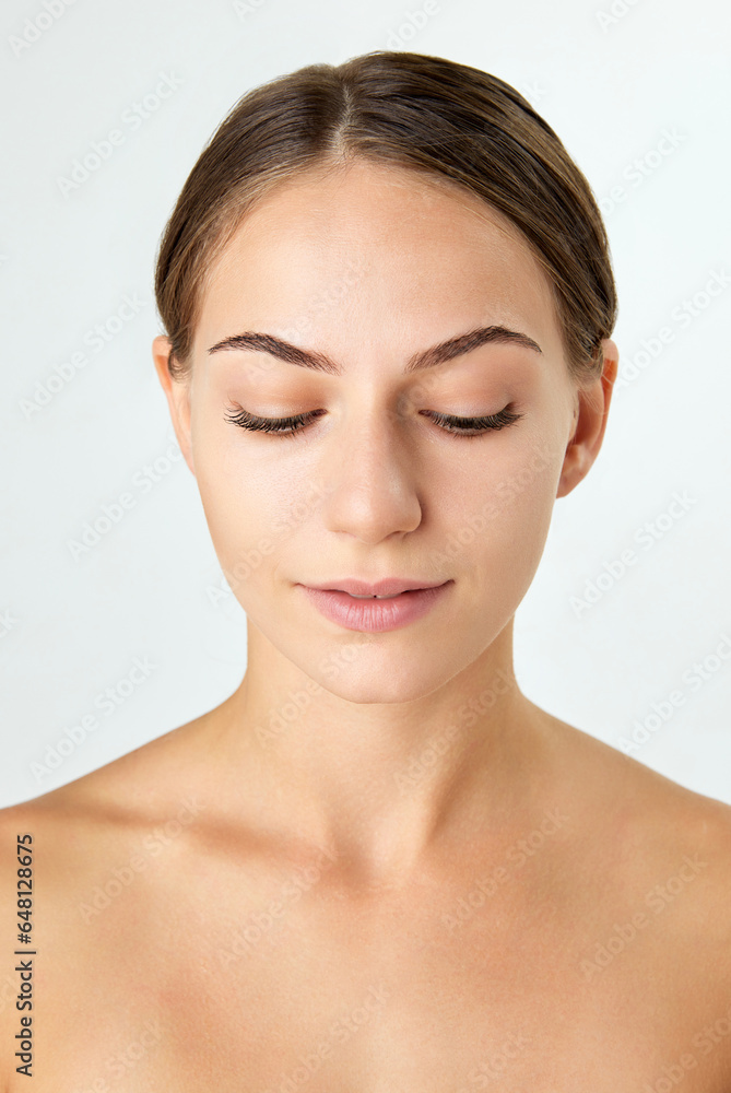 Portrait of young, beautiful woman with healthy, smooth, well-kept skin looking down isolated on white background. Concept of natural beauty, cosmetology and cosmetics, skin care, spa. Ad Portrait of young, beautiful woman with healthy, smooth, well-kept skin looking down isolated on white background. Concept of natural beauty, cosmetology and cosmetics, skin care, spa. Ad