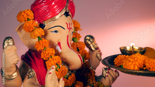 Female hands offering her prayers to Lord Ganesha with an Aarti Thali on Ganesh Chaturthi. Indian God statue during Indian Hindu festival - Ritual during prayer at temple photo