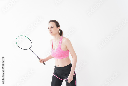 スポーツウェアを着てバドミントンをする外国人の女性