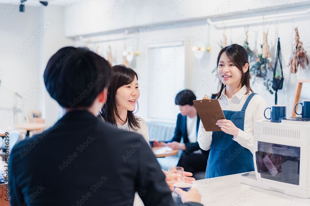 カフェで注文を取る若いスタッフ カフェで注文を取る若いスタッフ
