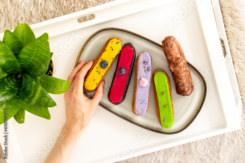 Many various glased eclairs with chocolate and berrie. Sweet food background photo