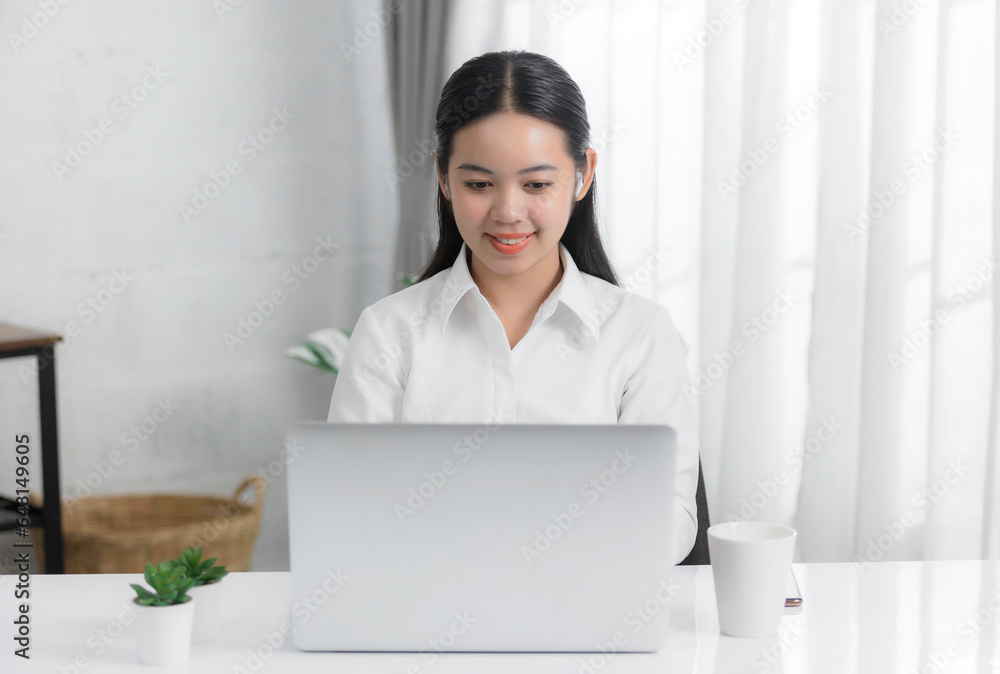 Asian young woman sitting at desk in office and drinking coffee, happy with the work they do on their tablet, laptop and taking notes at the modern office. Asian young woman sitting at desk in office and drinking coffee, happy with the work they do on their tablet, laptop and taking notes at the modern office.