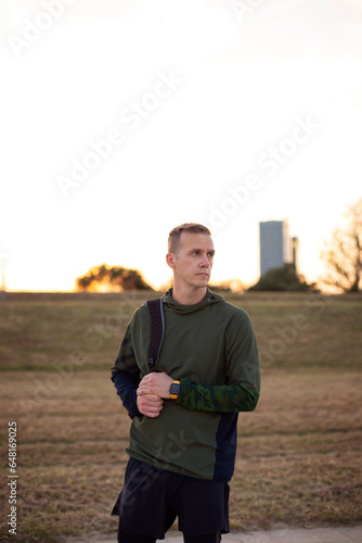 Man in the park with a bag on a walk  portrait of an athlete