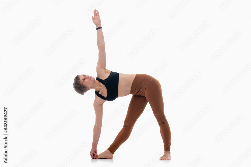 Utthita Trikonasana (Triangle Pose), Ashtanga yoga Side view of woman wearing sportswear doing Yoga exercise against white background. Utthita Trikonasana (Triangle Pose), Ashtanga yoga Side view of woman wearing sportswear doing Yoga exercise against white background.
