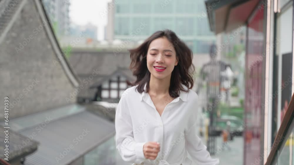 Slow motion of Young Asian woman happy running in the urban city street of Chengdu China Slow motion of Young Asian woman happy running in the urban city street of Chengdu China