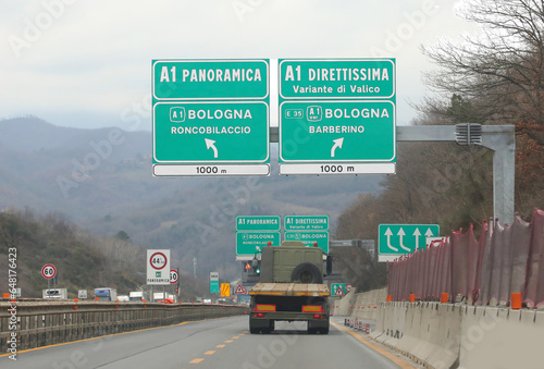 wide road sign in the italian motorway with place of city and two way to Tuscany photo